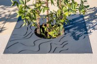 Custom tree grate with waterways perforation, powdercoated in Textura Monument.