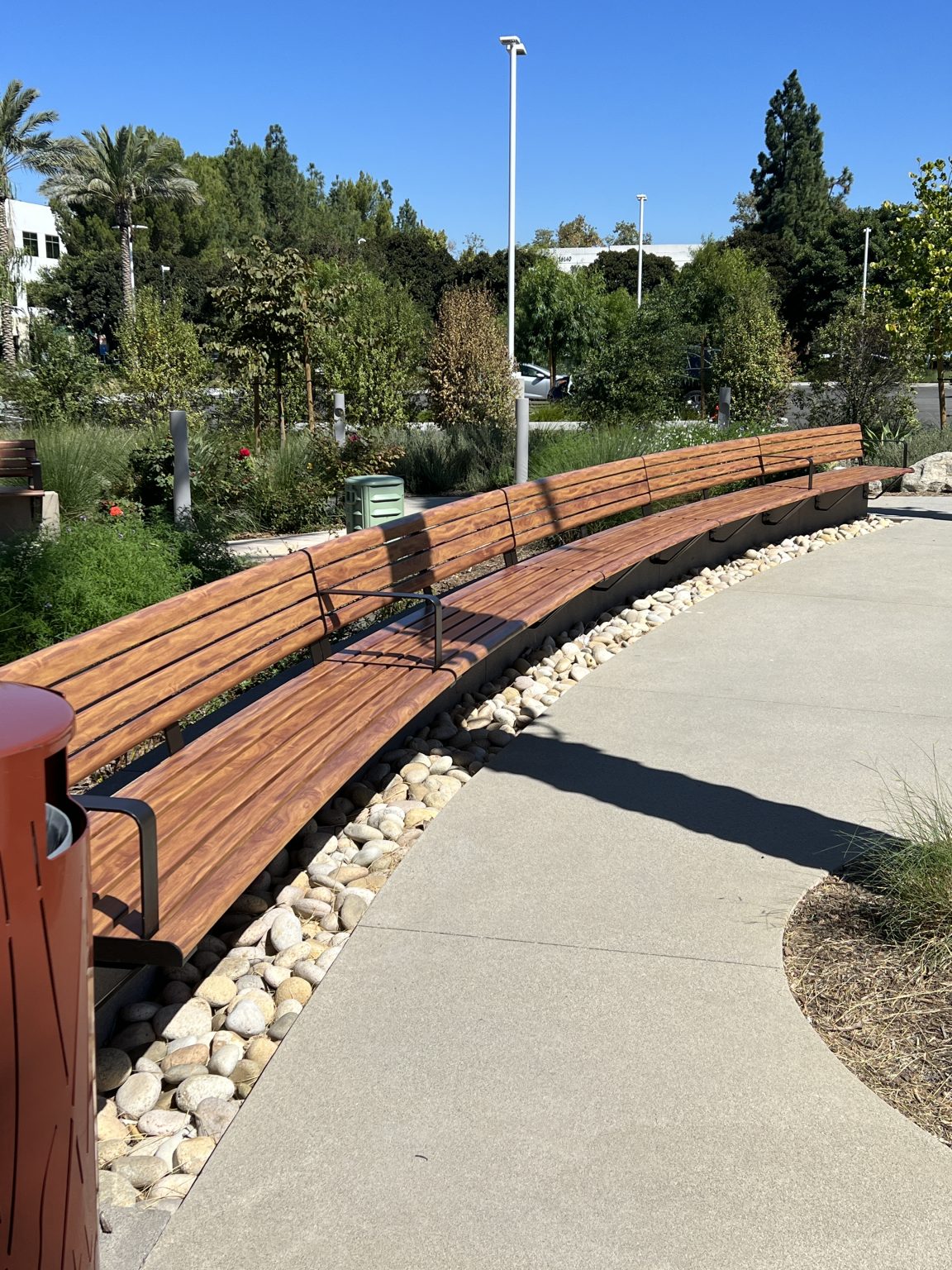 Linea Curved Seat (LIS10-C), tailored curve with alum Spotted Gum battens and Textura Dark Bronze frame.