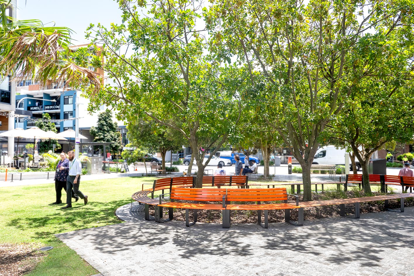 Curved and straight Linea Seats with frames in Textura Monument, battens in Bistro Orange and aluminium woodgrain Spotted Gum.
