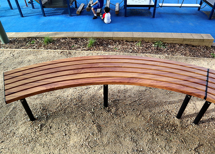 Mall Curved Slim Bench, battens in aluminium woodgrain Spotted Gum, frames in Night Sky.