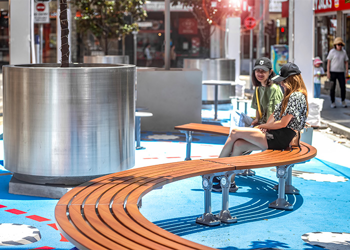 Mall Curved Slim Bench (CMM8-C) with aluminium Bush Cherry battens, Palladium Silver frame.
