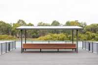 Classic Plaza Back-to-Back Seat with aluminium woodgrain battens in Spotted Gum, Sable Bass frame.