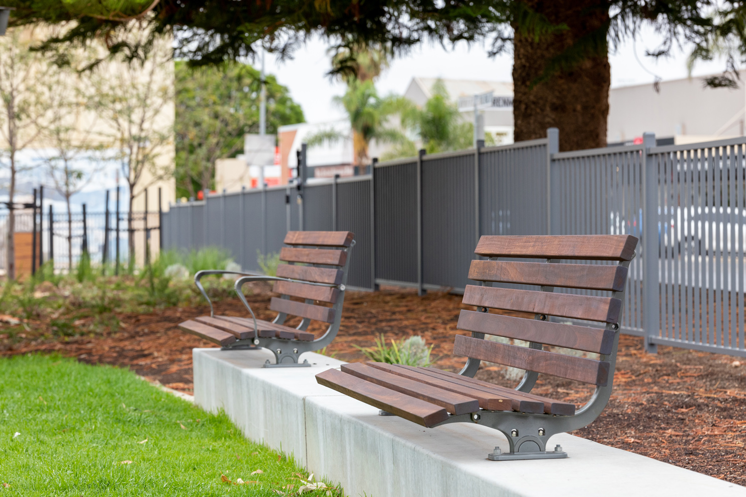 Plinth-mounted Mall DDA Seats with Jarrah battens and frames in tailored colour Metropolis Storm Pearl grey.