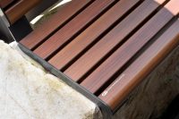 Linea Seat (LIS10, 1500mm) plinth-fixed with aluminium woodgrain Bush Cherry battens, Monument frame.