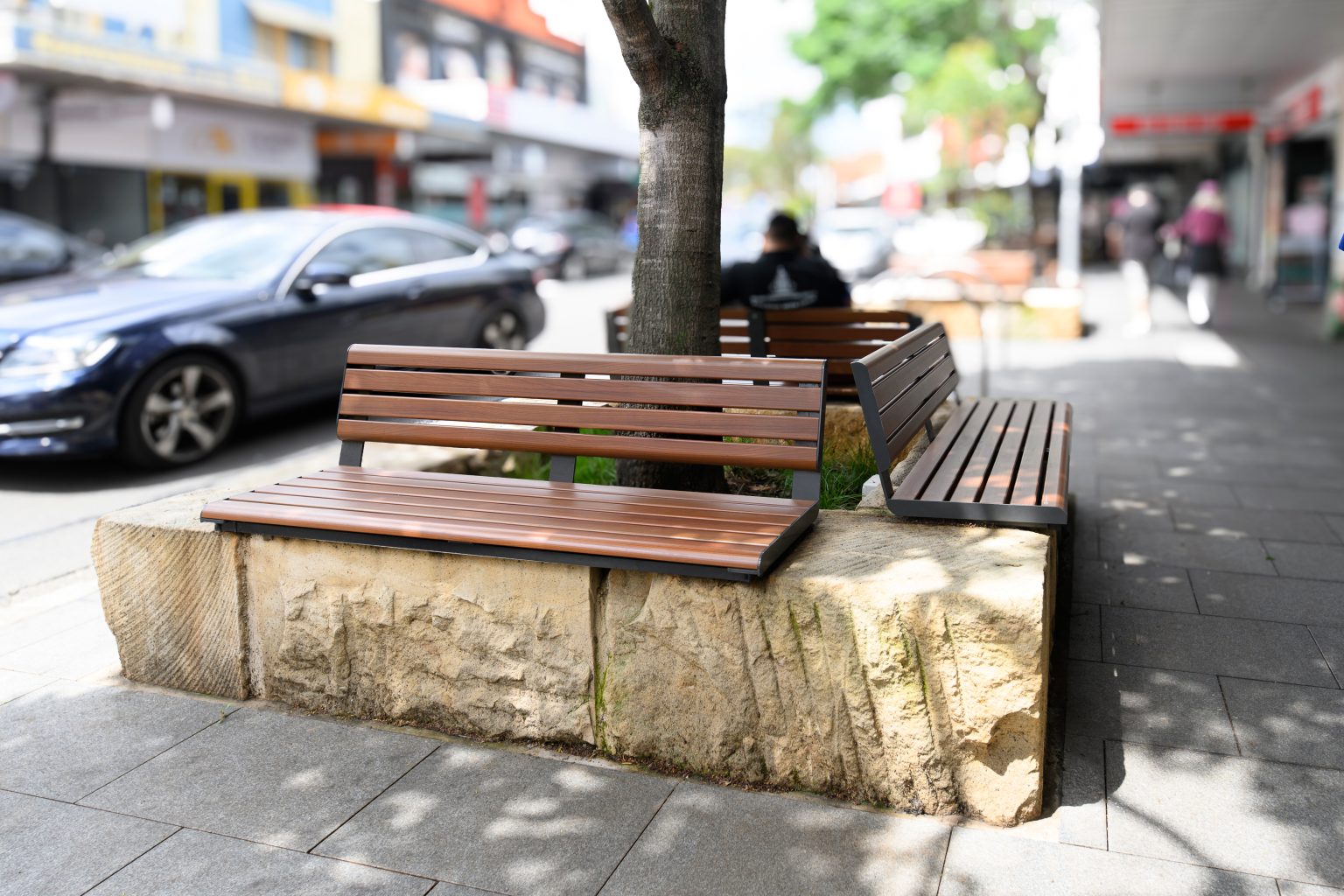 Linea Seat (LIS10, 1500mm) plinth-fixed with aluminium woodgrain Bush Cherry battens, Monument frame.