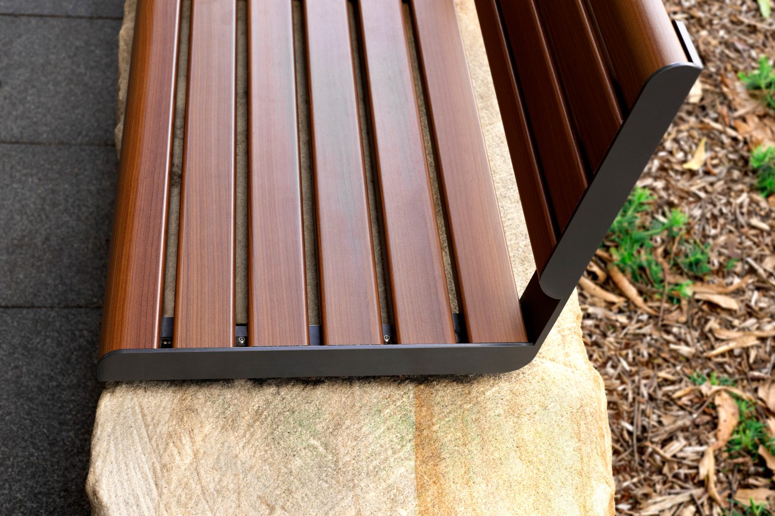 Linea Seat (LIS10, 1500mm) plinth-fixed with aluminium woodgrain Bush Cherry battens, Monument frame.