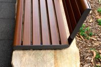 Linea Seat (LIS10, 1500mm) plinth-fixed with aluminium woodgrain Bush Cherry battens, Monument frame.