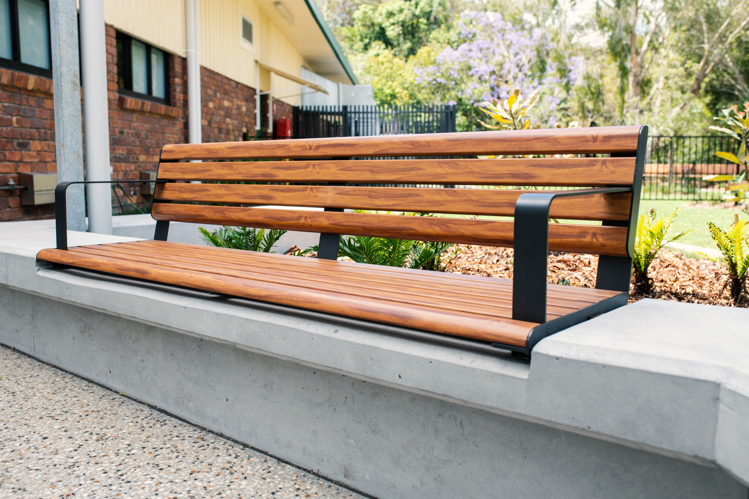 Linea Seat (LIS10) 1800mm with aluminium woodgrain Spotted Gum battens, Monument frame, plinth-fixed.