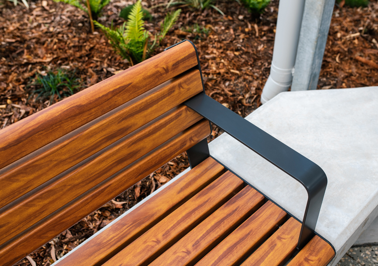 Linea Seat (LIS10) 1800mm with aluminium woodgrain Spotted Gum battens, Monument frame, plinth-fixed.