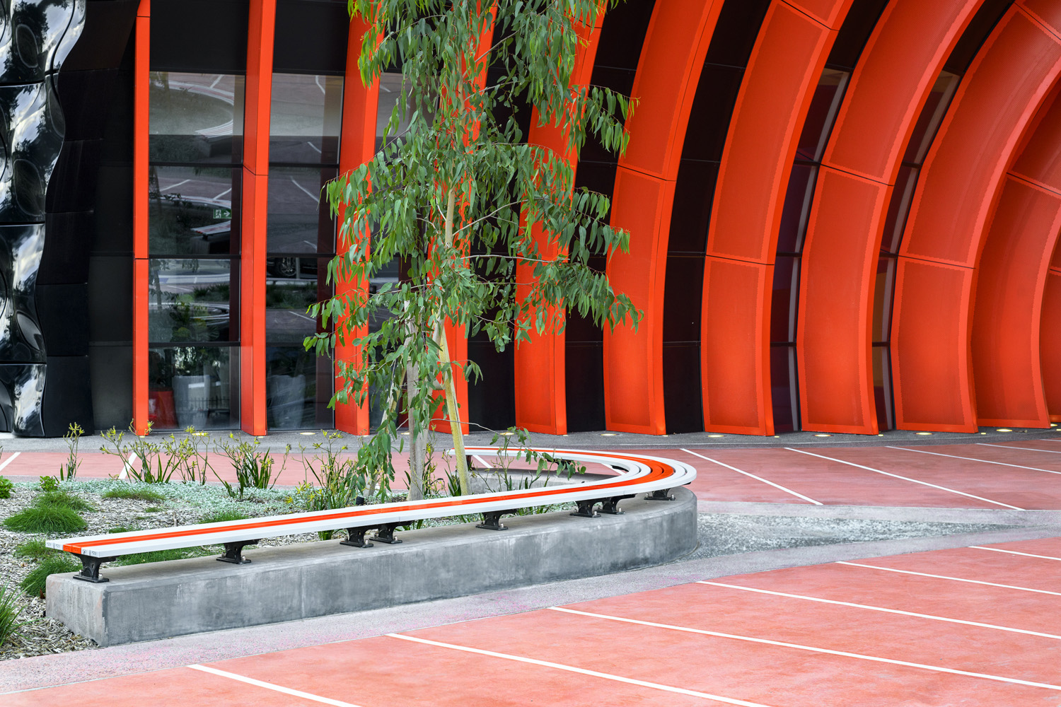Mall Slim Bench, curved (CMM8-C) and straight (CMM8) plinth-fixed with Textura Silver and Sensation Orange battens, Charcoal frame.