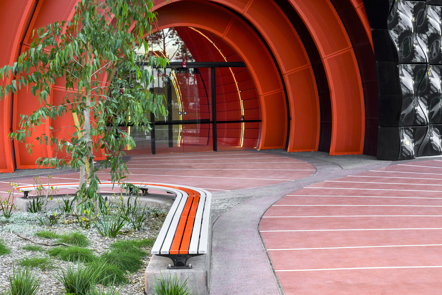 Mall Slim Bench, curved (CMM8-C) and straight (CMM8) plinth-fixed with Textura Silver and Sensation Orange battens, Charcoal frame.