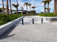Wide Bollards protect pedestrians traversing from the carpark to amphitheatre, through green space.