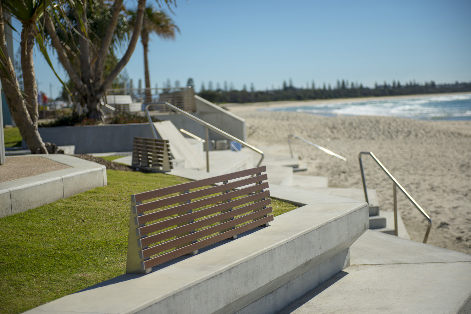 Custom seats on concrete plinths with aluminium woodgrain Woodland Grey battens.