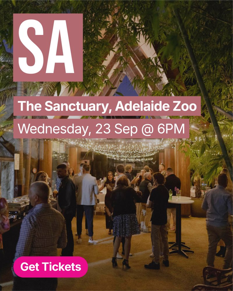 Busy indoor event at The Sanctuary, Adelaide Zoo with guests mingling under hanging lights; foreground shows a magenta Get Tickets button.
